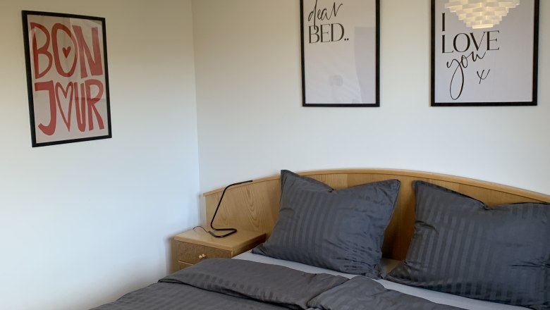 TDR-Chalet Wienerwald- cozy bedroom, © Obermeier Room with double bed and pictures on the wall