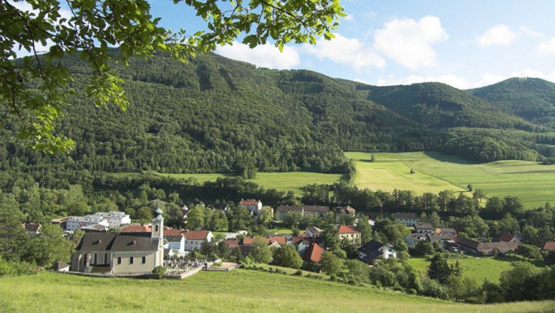 Altenmarkt, © Wingrafik Blick auf Altenmarkt mit Kirche und grüner Landschaft im Hintergrund.