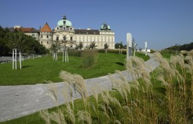 Teichgarten, © Stift Klosterneuburg Schloss mit grünem Dach, umgeben von gepflegtem Garten und Gehweg.