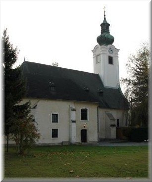 Schwadorf, © Pfarre Schwadorf Kirche mit Turm und grünem Dach in Schwadorf.