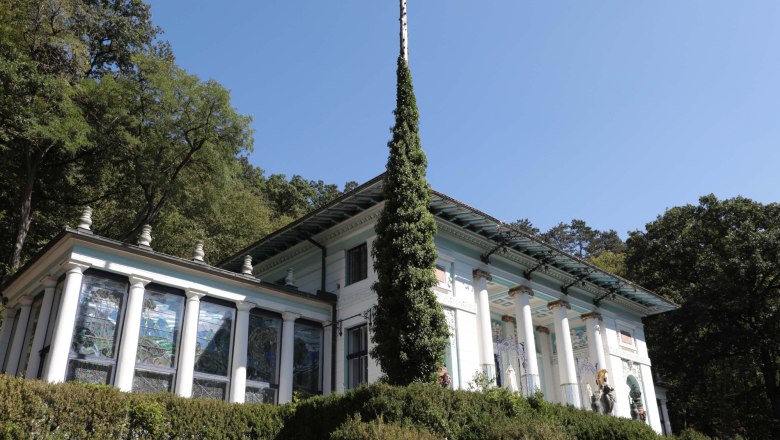 Ernst-Fuchs Museum, © Michael Duerr Ernst-Fuchs-Museum mit Säulen und Glasfenstern, umgeben von Bäumen.