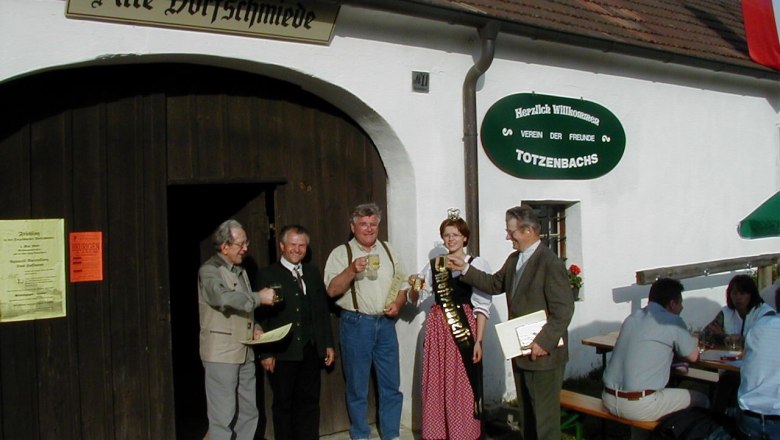 Old village smithy, © Alte Dorfschmiede Group of people clinking glasses in front of the old village smithy in Totzenbach.