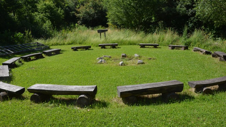 Für eine Auszeit in der Gemeinschaft, © Andreas Nagl Ein Kreis aus Holzbänken auf einer Wiese, umgeben von Bäumen.