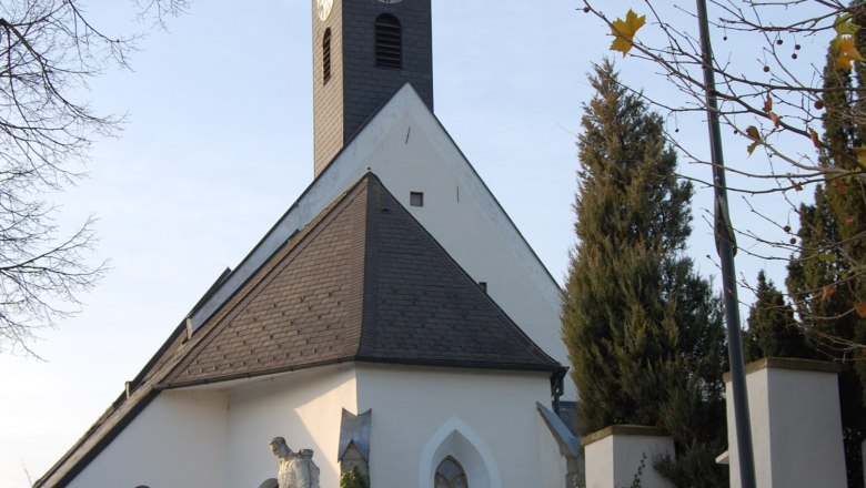 Gotische Kirche Kirchstetten, © Gotische Kirche Kirchstetten Gotische Kirche in Kirchstetten mit Turm und Statue im Vordergrund.