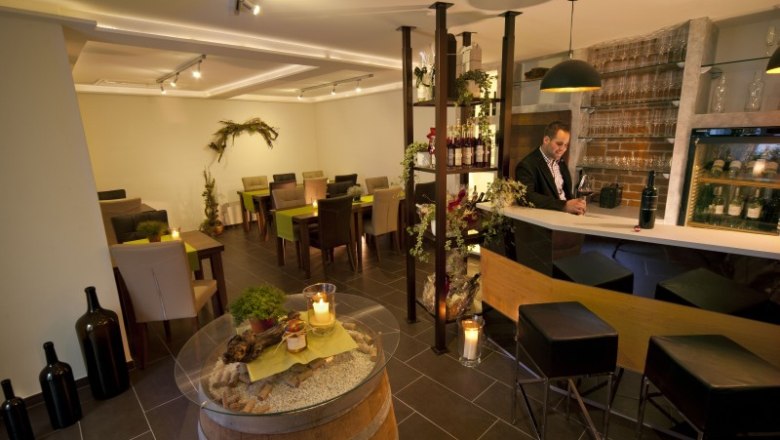 Verkostungsraum, © Weingut Artner Ein stilvoller Verkostungsraum mit Bar, Tischen und Dekoration.