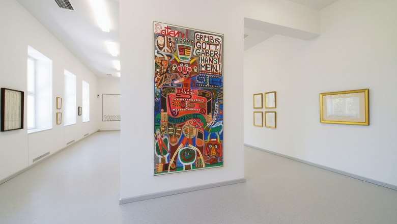 museum gugging, © Privatstiftung der Künstler Gugging Innenansicht eines Museums mit moderner Kunst an den Wänden.