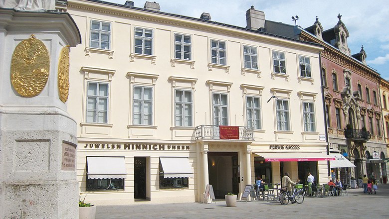 Kaiserhaus Baden, © Stadtgemeinde Baden Historisches Gebäude in Baden mit Geschäften im Erdgeschoss.