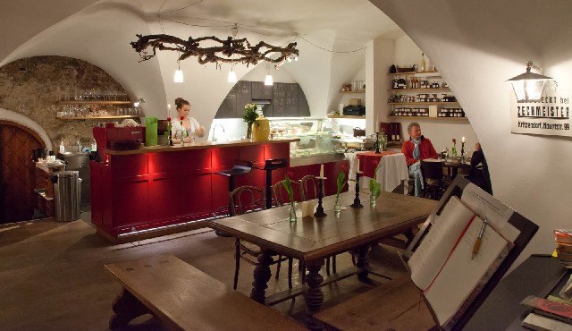 Wein+Deli, Hauerhof 99, © I.R. Gemütliches Café mit roter Theke und Holztischen.