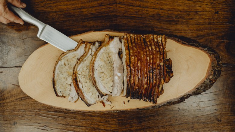 Classics and theme weeks, © Niederösterreich Werbung/Rita Newman Sliced roast pork on a wooden board.