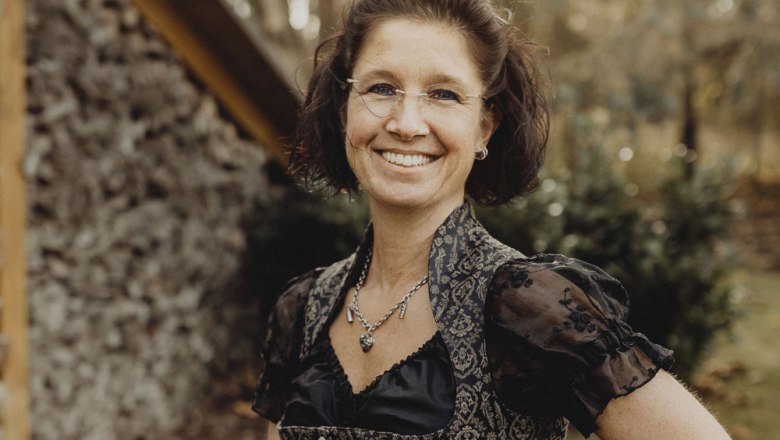 Landlady Martina Skilitz, © Niederösterreich Werbung/Sophie Menegaldo Woman in traditional dress smiling outdoors.