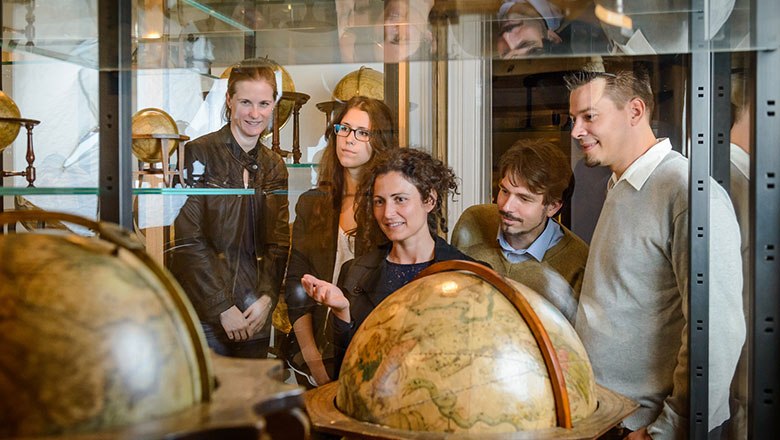 Globe, Papyrus and Esperanto Museum, © Österreichische Nationalbibliothek Group of people looking at antique globes in a museum.