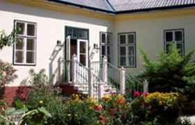 Außenansicht Haus Reindl, © Margarethe Thelen Außenansicht eines Hauses mit Garten und Blumen.