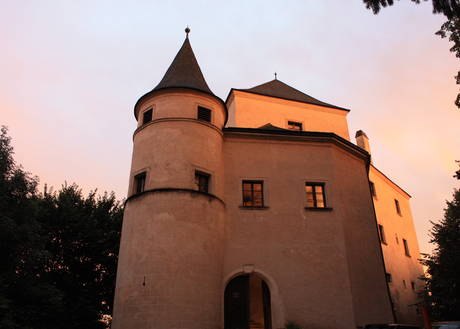Burg Wildegg, © Burg Wildegg Burg Wildegg bei Sonnenuntergang mit beleuchteten Türmen und Fenstern.