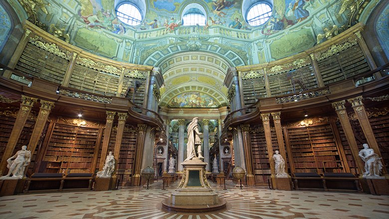 Österreichische Nationalbibliothek, © Österreichische Nationalbibliothek Prunksaal der Österreichischen Nationalbibliothek mit Statue und Deckenfresken.