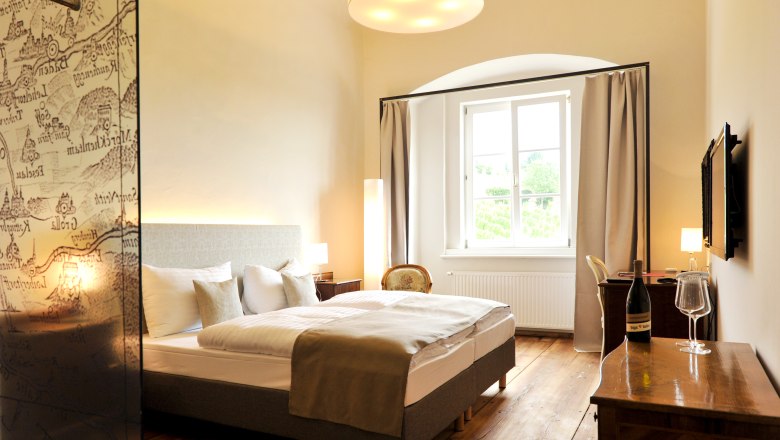 Room, © Freigut Thallern Elegant hotel room with double bed, wooden floor and large window.