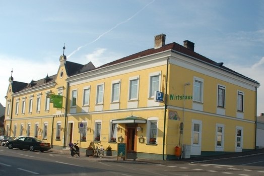 Eingang, © Gasthof Smrcka Gelbes Wirtshaus an einer Straßenecke mit mehreren Fenstern und einem Eingang.