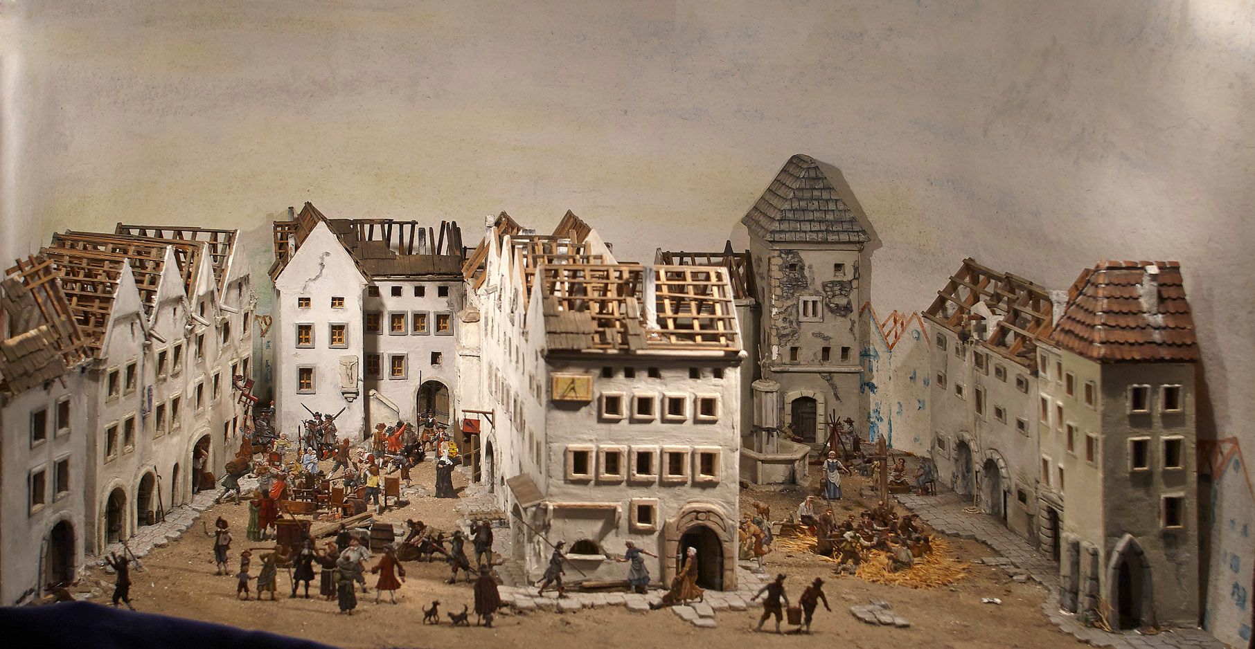 Miniaturstadt mit Figuren in einem historischen Setting.