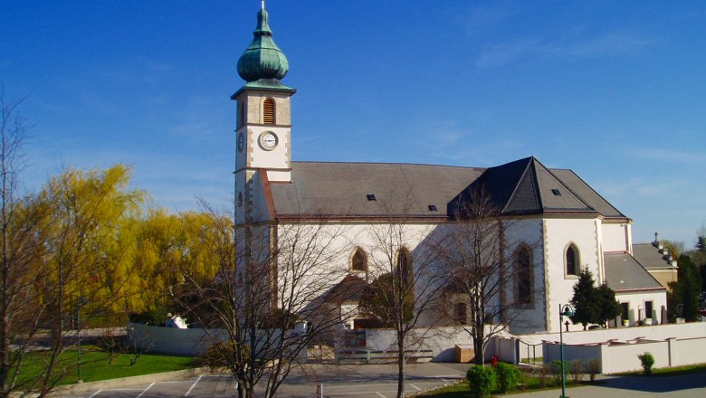 Kirche in Trumau mit blauem Himmel im Hintergrund.