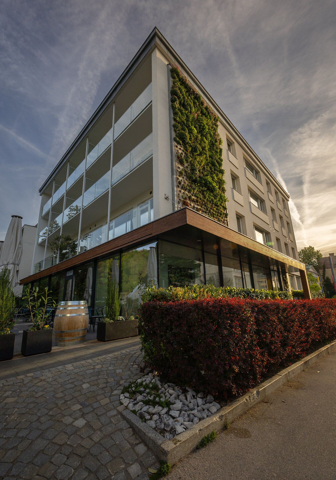 Ein modernes Hotel, umgeben von üppigem Grün, lädt dazu ein, die Ruhe der Natur zu genießen. Die harmonische Architektur fügt sich perfekt in die malerische Landschaft ein und verspricht unvergessliche Momente der Entspannung.