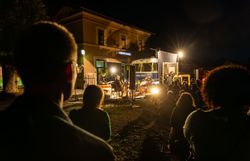 Unter dem funkelnden Sternenhimmel versammeln sich Menschen, um die Klänge eines einzigartigen Kulturabends zu genießen. Die warmen Lichter der Bühne schaffen eine einladende Atmosphäre, während die sanfte Brise die Vorfreude auf das bevorstehende Erlebnis verstärkt.