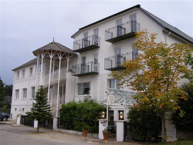 Ein mehrstöckiges Gebäude mit Balkonen und einem Eingang mit Säulen.