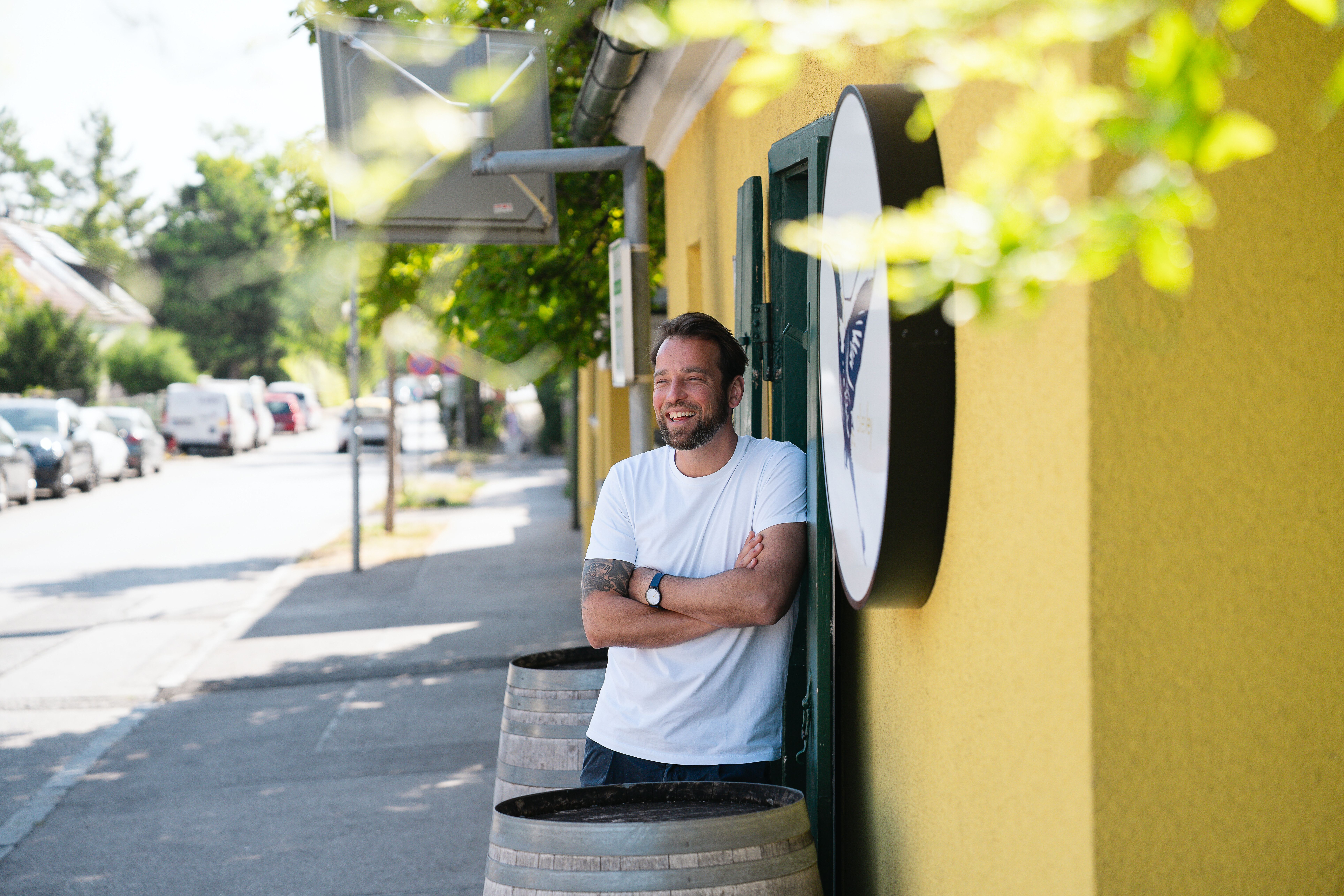 Gelbe Strahlkraft und ein Lächeln. Johannes Ley, lässig lehnend vor dem einladend gelb gefärbten Allerley, verkörpert die Freundlichkeit seines Restaurants. Ein starker Auftritt, der Aufmerksamkeit erweckt.
