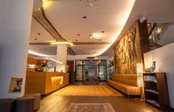 Der Empfangsbereich des Hotels strahlt eine einladende Atmosphäre aus, die durch warmes Licht und stilvolle Einrichtung ergänzt wird. Die harmonische Verbindung von modernem Design und gemütlicher Eleganz lädt dazu ein, sich sofort wohlzufühlen und die Annehmlichkeiten des Aufenthalts zu genießen.