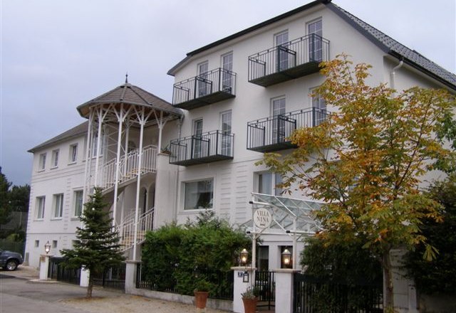 Ein mehrstöckiges Gebäude mit Balkonen und einem Eingang mit Säulen.