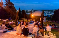 Mondscheinkonzert in Baden bei Wien. Besucher:innen sitzen vor dem malerischen Beethoventempel.