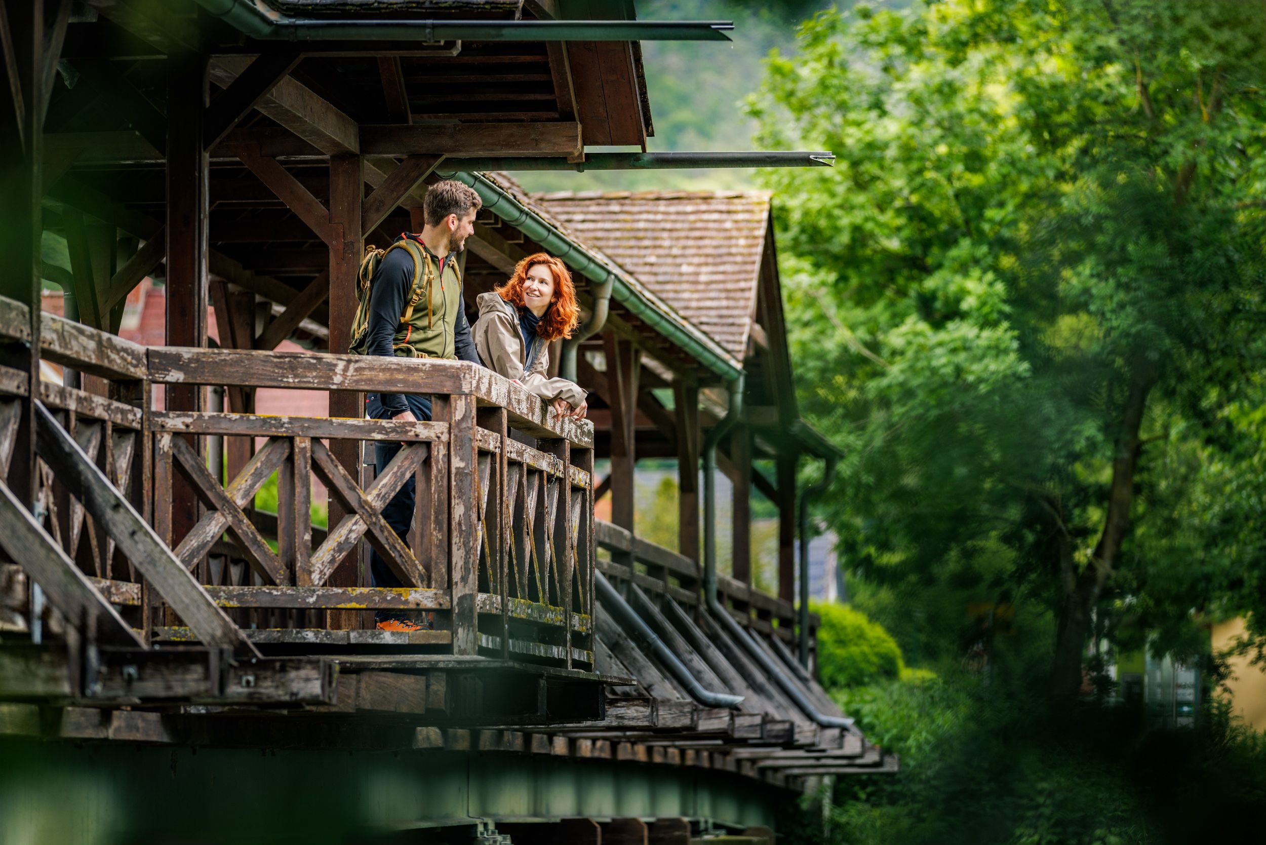 Ein Paar auf einer Ausbuchtung einer Holzbrücke, die über die Leitha führt