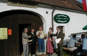 Gruppe von Menschen vor der Alten Dorfschmiede in Totzenbach, die ansto&szlig;en.
