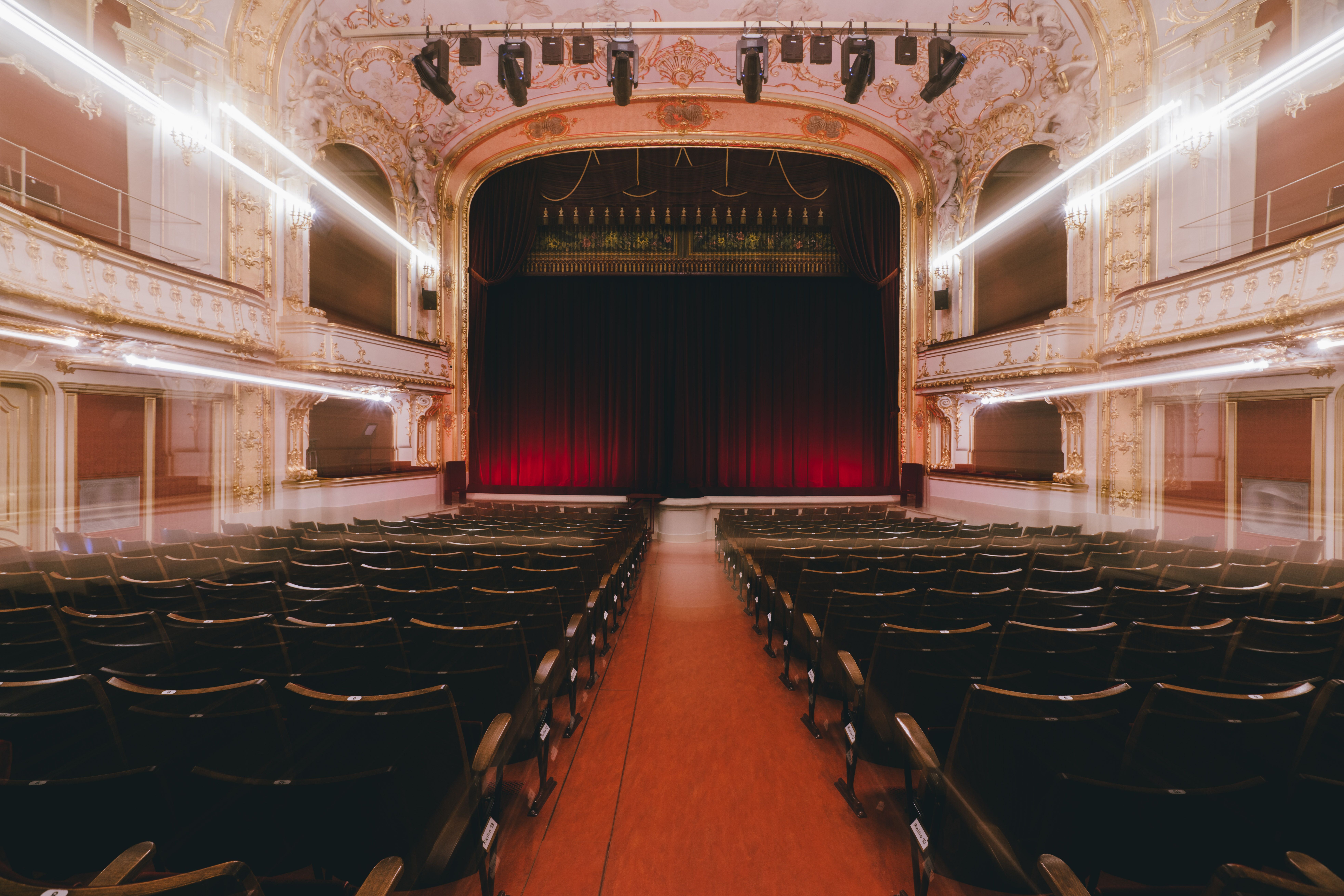 Das Stadttheater Berndorf strahlt eine einladende Atmosphäre aus, die die Vorfreude auf unvergessliche Aufführungen weckt. Die prächtigen Verzierungen und der rote Vorhang versprechen ein Erlebnis voller Emotionen und Kunstgenuss. Hier treffen sich Kulturbegeisterte, um gemeinsam in die Welt des Theaters einzutauchen.