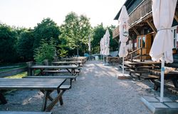 Gastgarten vom Peilsteinhaus mit Tischen, Bänken und Schirmen
