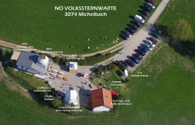 Aerial view of the Michelbach observatory with buildings, telescopes and parked cars.