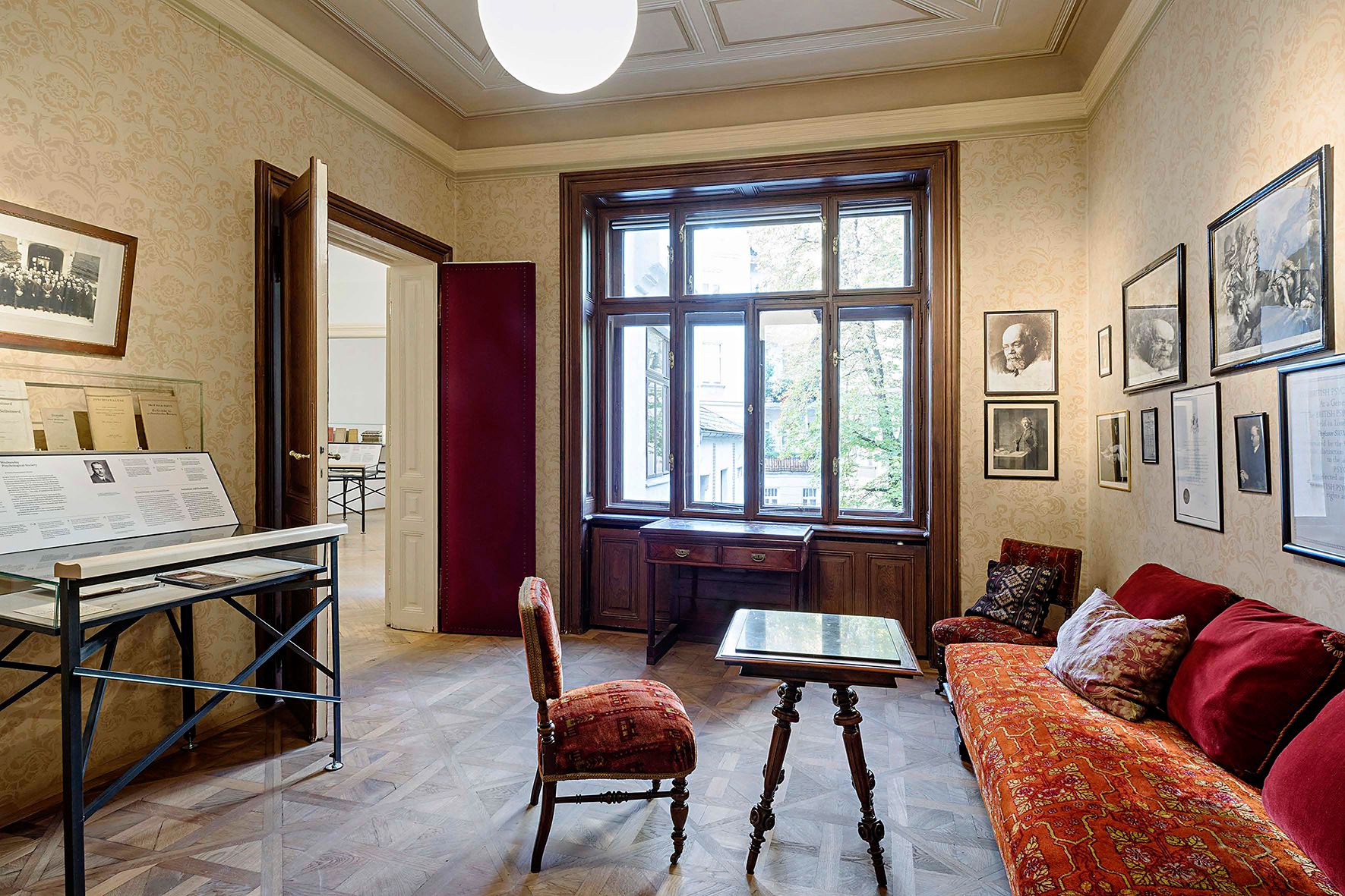 Innenansicht des Sigmund Freud Museums mit antiken Möbeln und Bildern an der Wand.