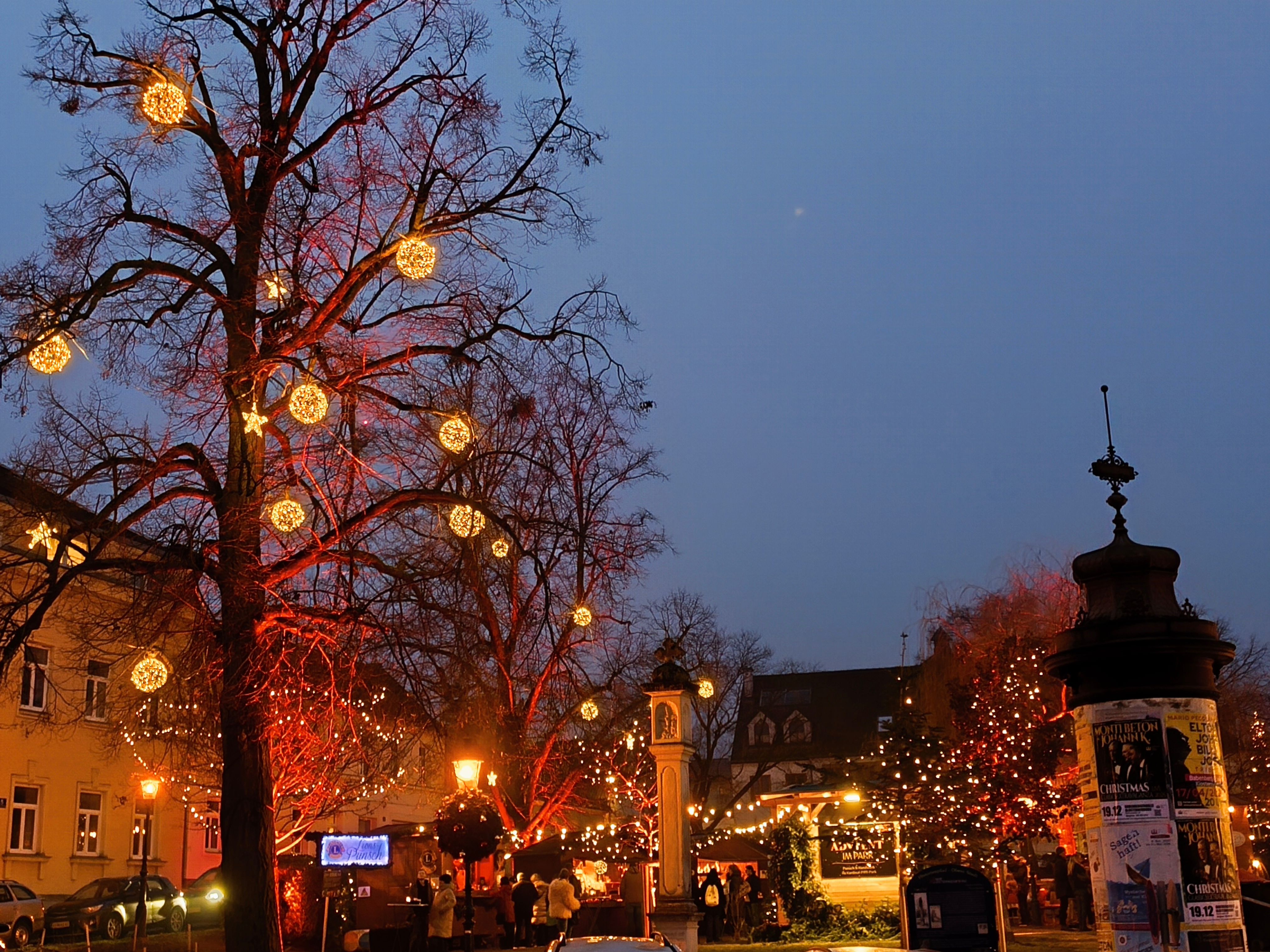 Weihnachtliche Beleuchtung in der Dunkelheit beim Adventmarkt im Kardinal Piffl Park. 