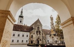 Inmitten der malerischen Kulisse des Wienerwaldes strahlt der Klostergasthof Heiligenkreuz eine einladende Atmosphäre aus. Die historische Architektur und die umgebenden Bäume laden dazu ein, die Ruhe und Schönheit der Natur zu genießen. Hier können Besucher die Seele baumeln lassen und die köstlichen regionalen Spezialitäten der Wirtshauskultur entdecken.