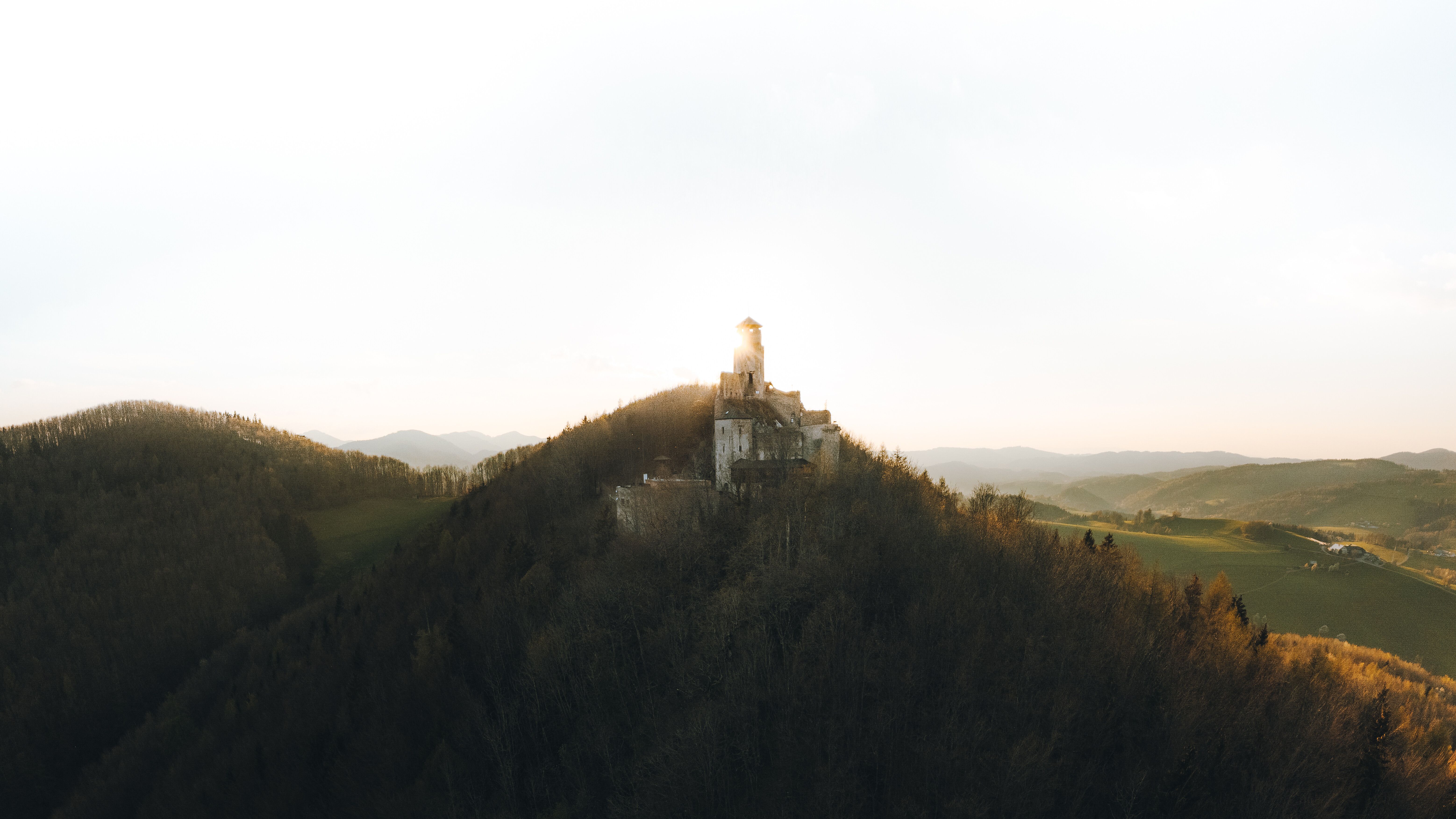Die sanften Hügel umarmen die majestätische Ruine, während die goldenen Strahlen der Abendsonne die Landschaft in ein warmes Licht tauchen. Hier, wo die Natur und Geschichte aufeinandertreffen, lädt die atemberaubende Aussicht dazu ein, die Seele baumeln zu lassen und die Stille der Umgebung zu genießen.