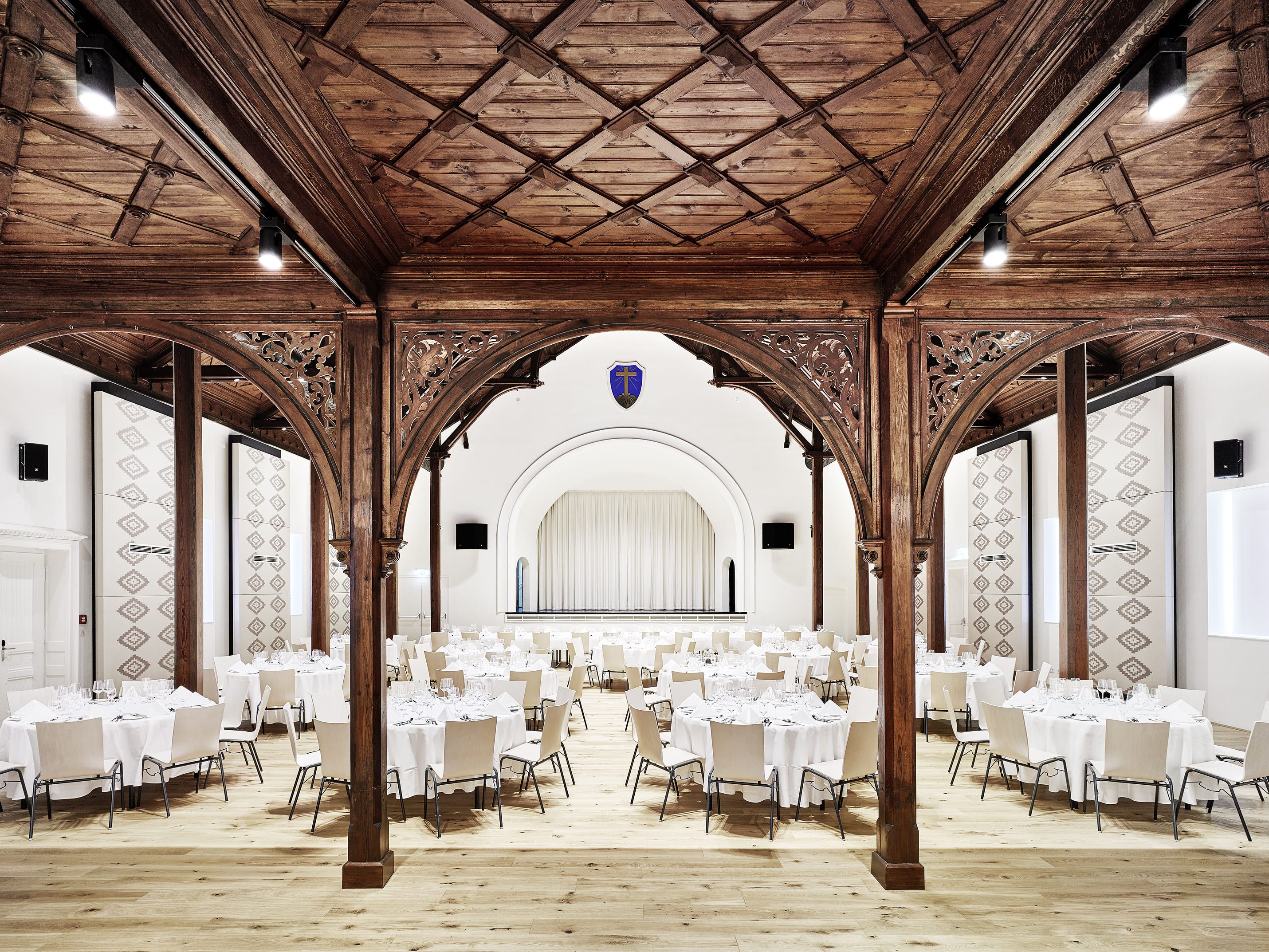 Festlich gedeckter Tisch im prunkvollen Saal im Gabrium mit verzierten Holzelementen.