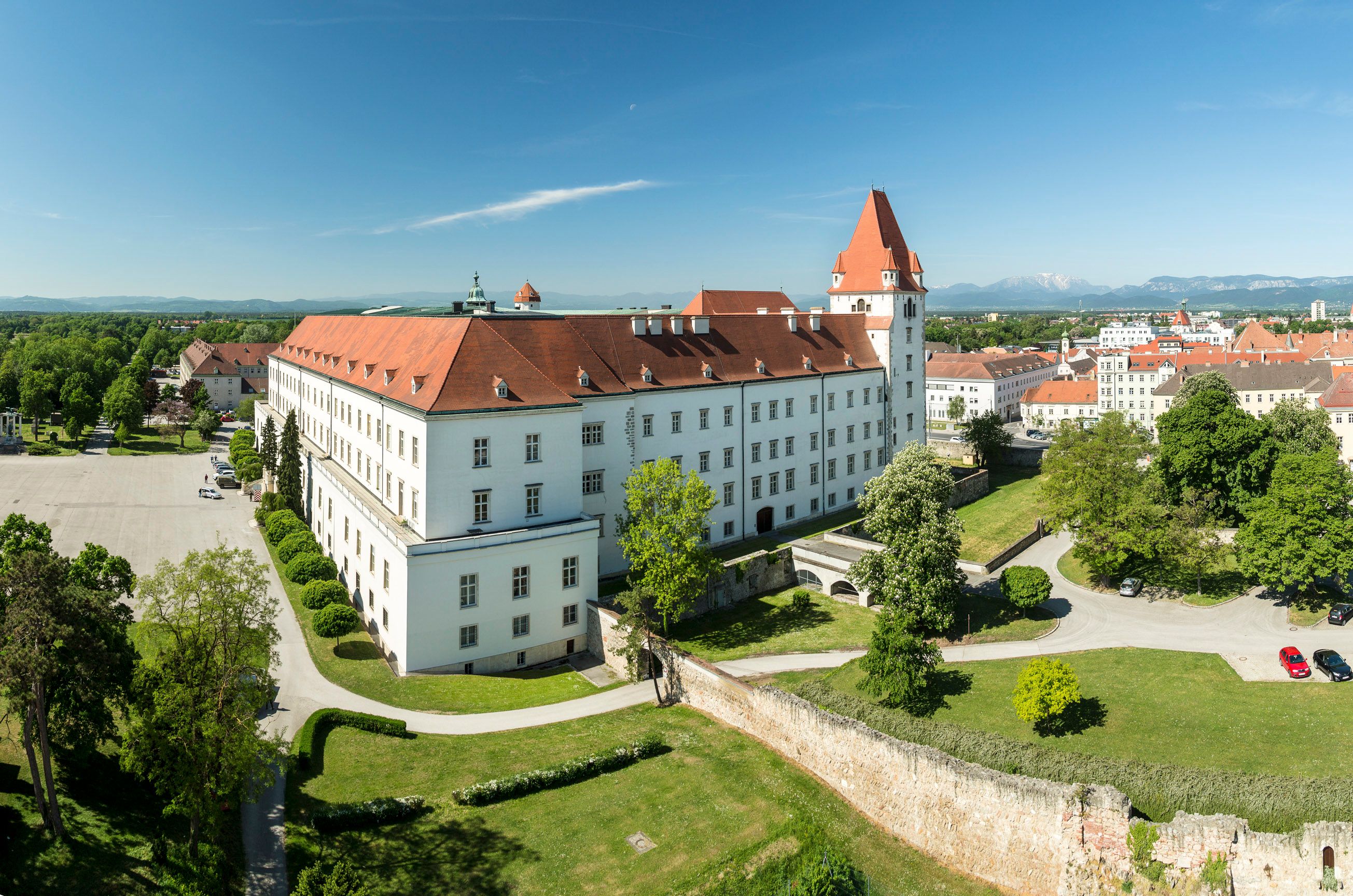 Luftaufnahme der Theresianischen Militärakademie in Österreich mit rotem Dach und umliegendem Grün.