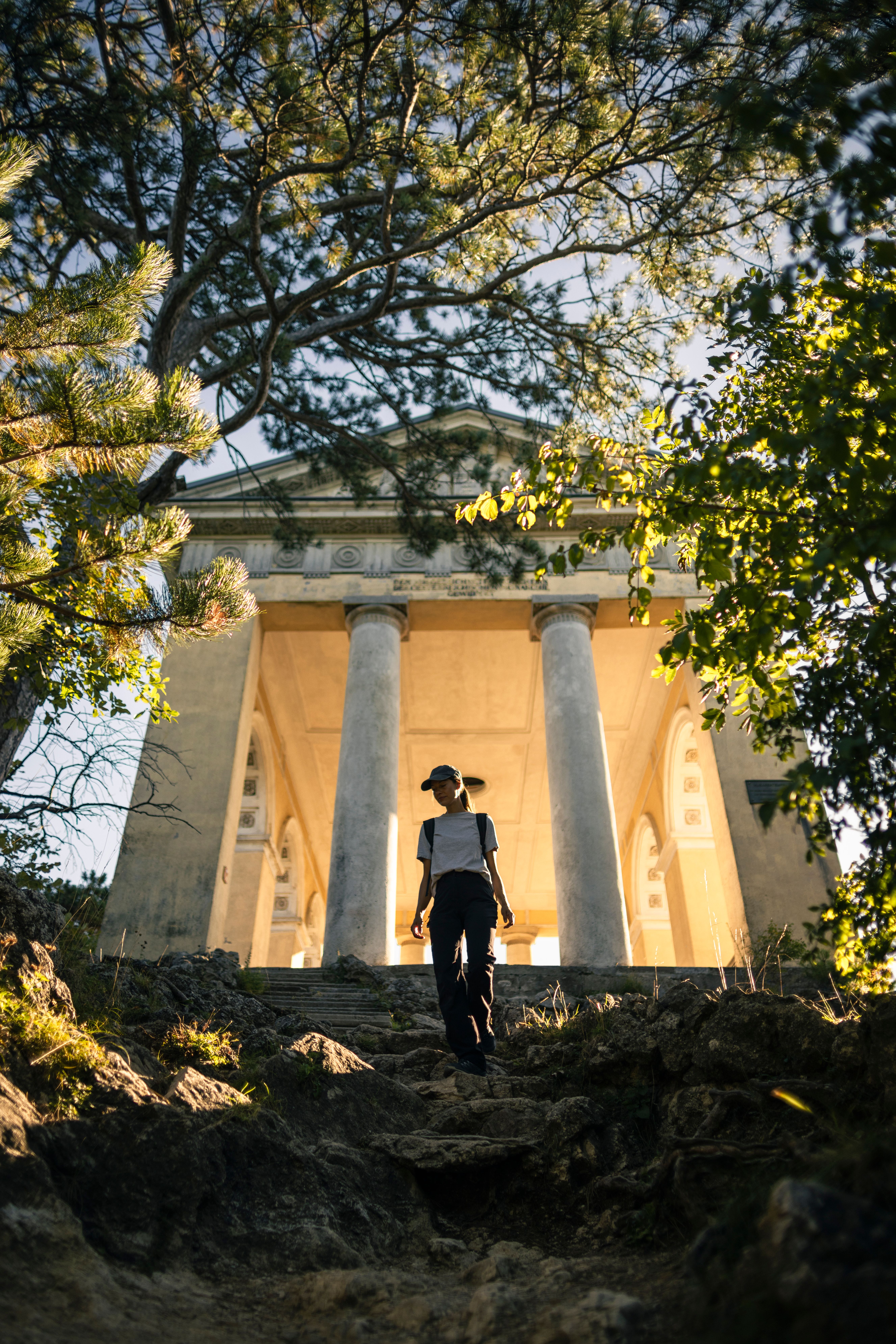 Frau wandert bergab, Husarentempel im Hintergrund