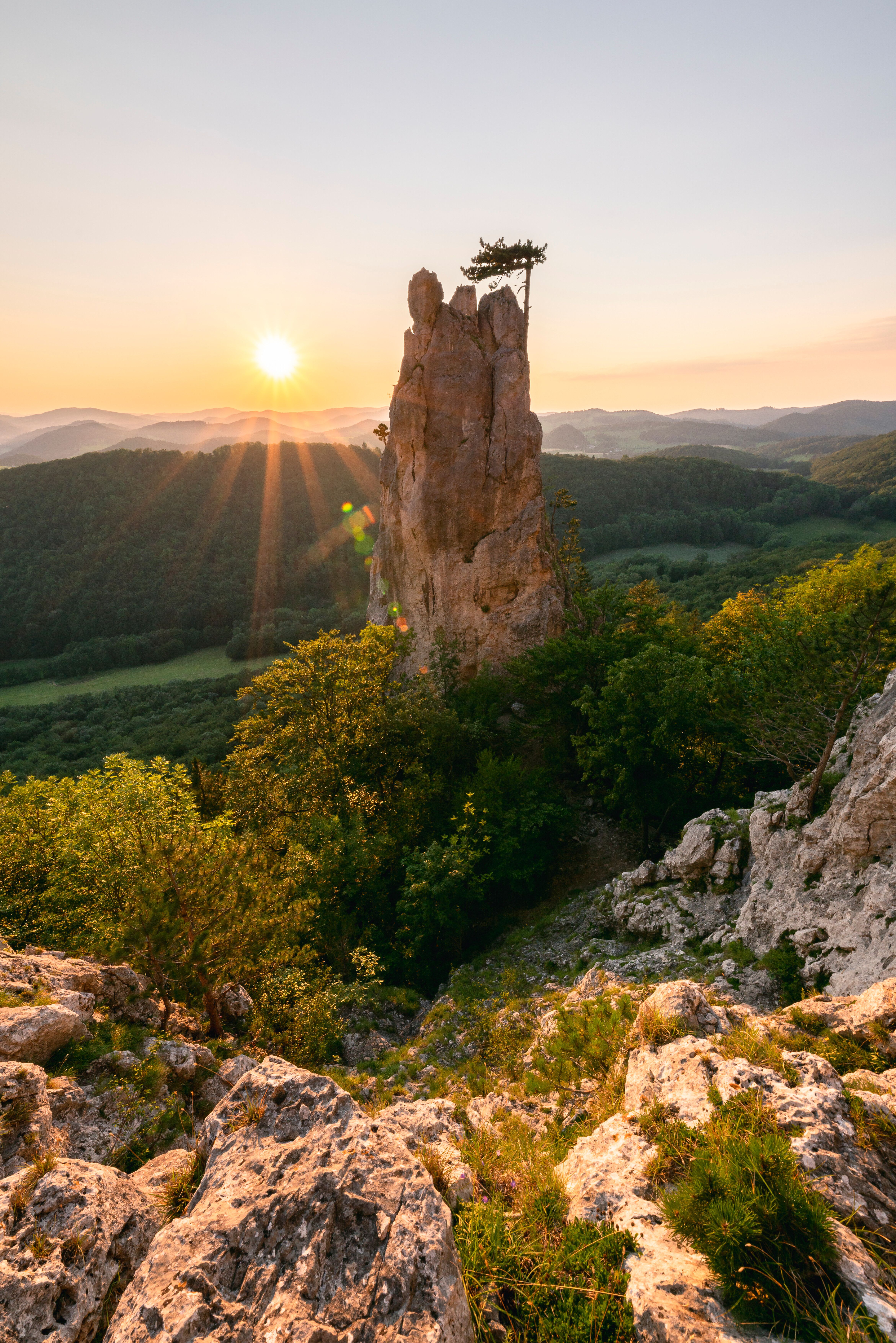 Die majestätischen Felsen des Peilsteins ragen stolz in den Himmel, während die Sonne sanft hinter den Bergen aufgeht. Umgeben von üppigem Grün und dem sanften Licht der Morgendämmerung, bietet dieser Ort eine atemberaubende Kulisse für Naturliebhaber und Abenteurer. Hier, wo die Stille der Natur mit dem Gesang der Vögel harmoniert, wird jeder Schritt zu einem unvergesslichen Erlebnis.