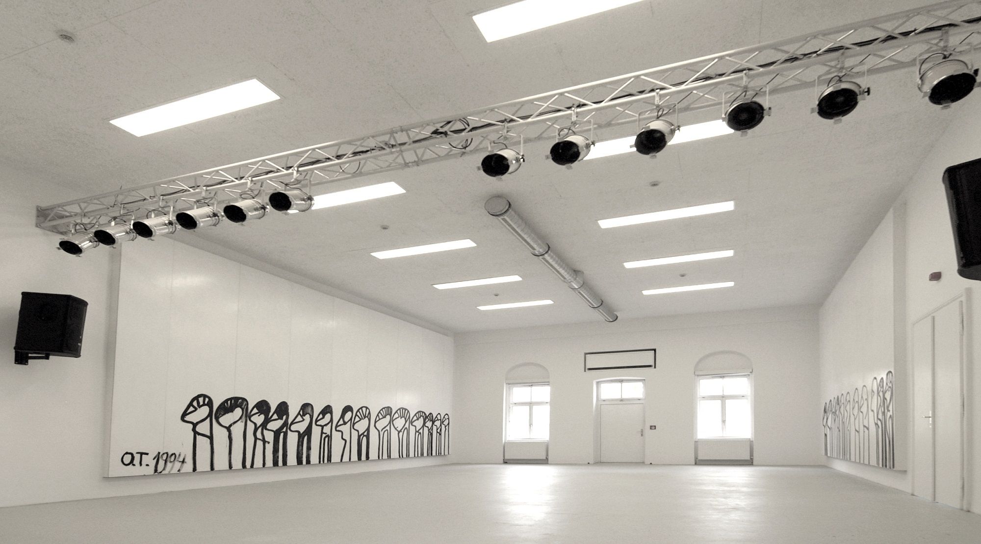 Interior view of a white room with wall paintings and lighting.