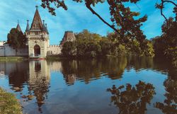 Die majestätische Franzensburg spiegelt sich im ruhigen Wasser des Teiches wider, umgeben von üppigem Grün und sanften Hügeln. Hier, wo Geschichte und Natur harmonisch verschmelzen, lädt die malerische Kulisse zu einem entspannten Spaziergang ein.