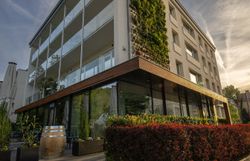 Ein modernes Hotel, umgeben von üppigem Grün, lädt dazu ein, die Ruhe der Natur zu genießen. Die harmonische Architektur fügt sich perfekt in die malerische Landschaft ein und verspricht unvergessliche Momente der Entspannung.