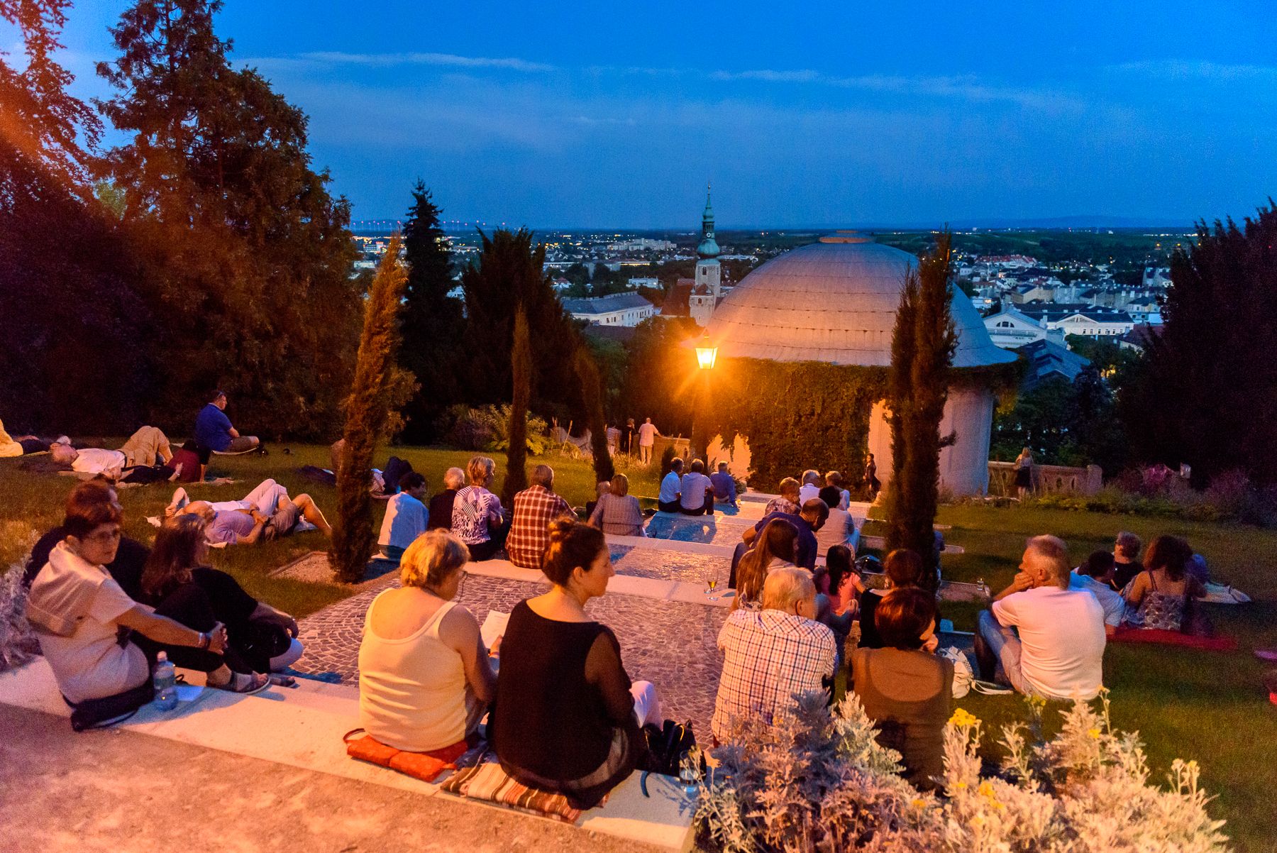 Mondscheinkonzert in Baden bei Wien. Besucher:innen sitzen vor dem malerischen Beethoventempel.