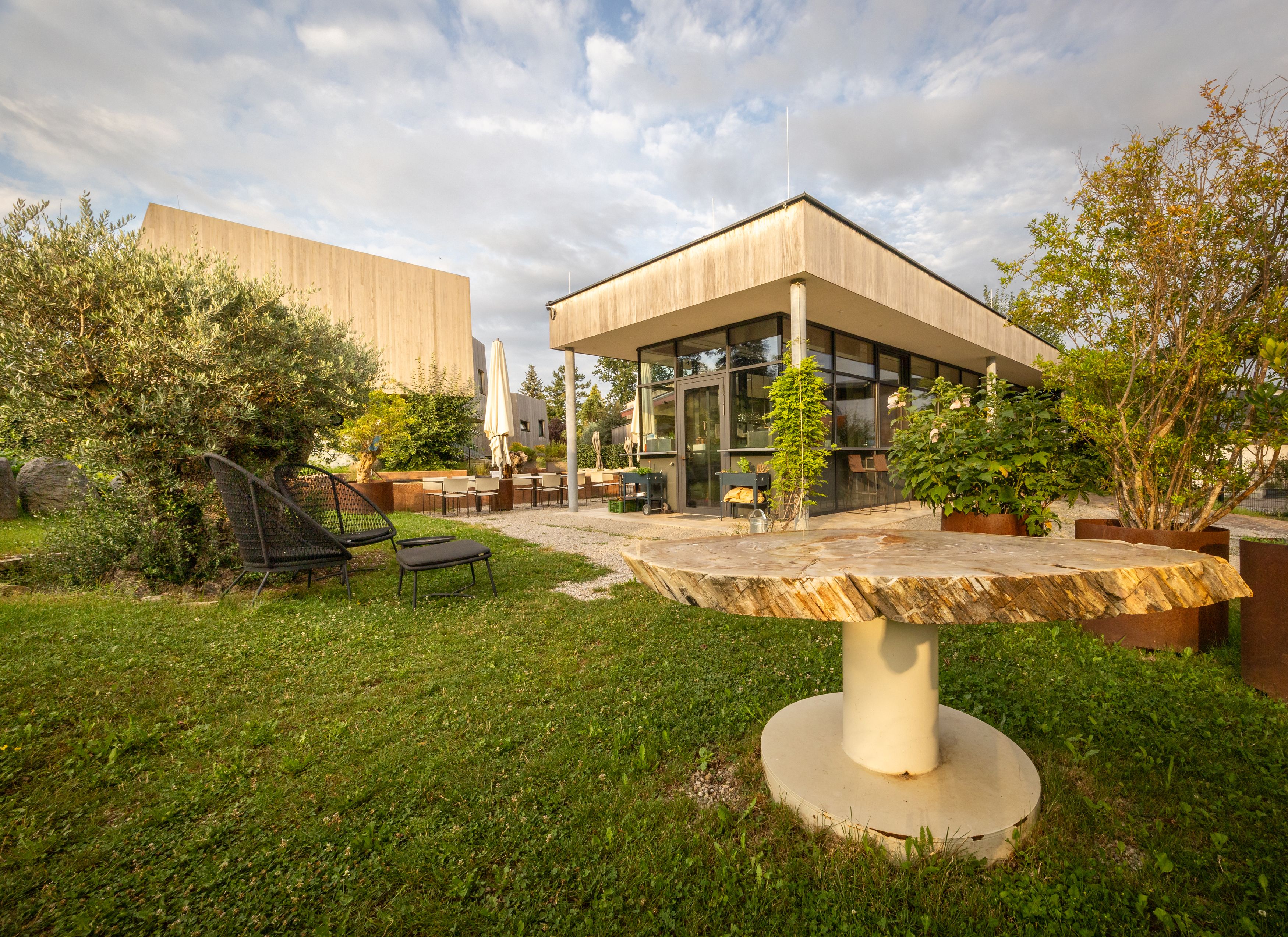 Gartenbereich eines modernen Hotels mit Sitzgelegenheiten und Pflanzen.