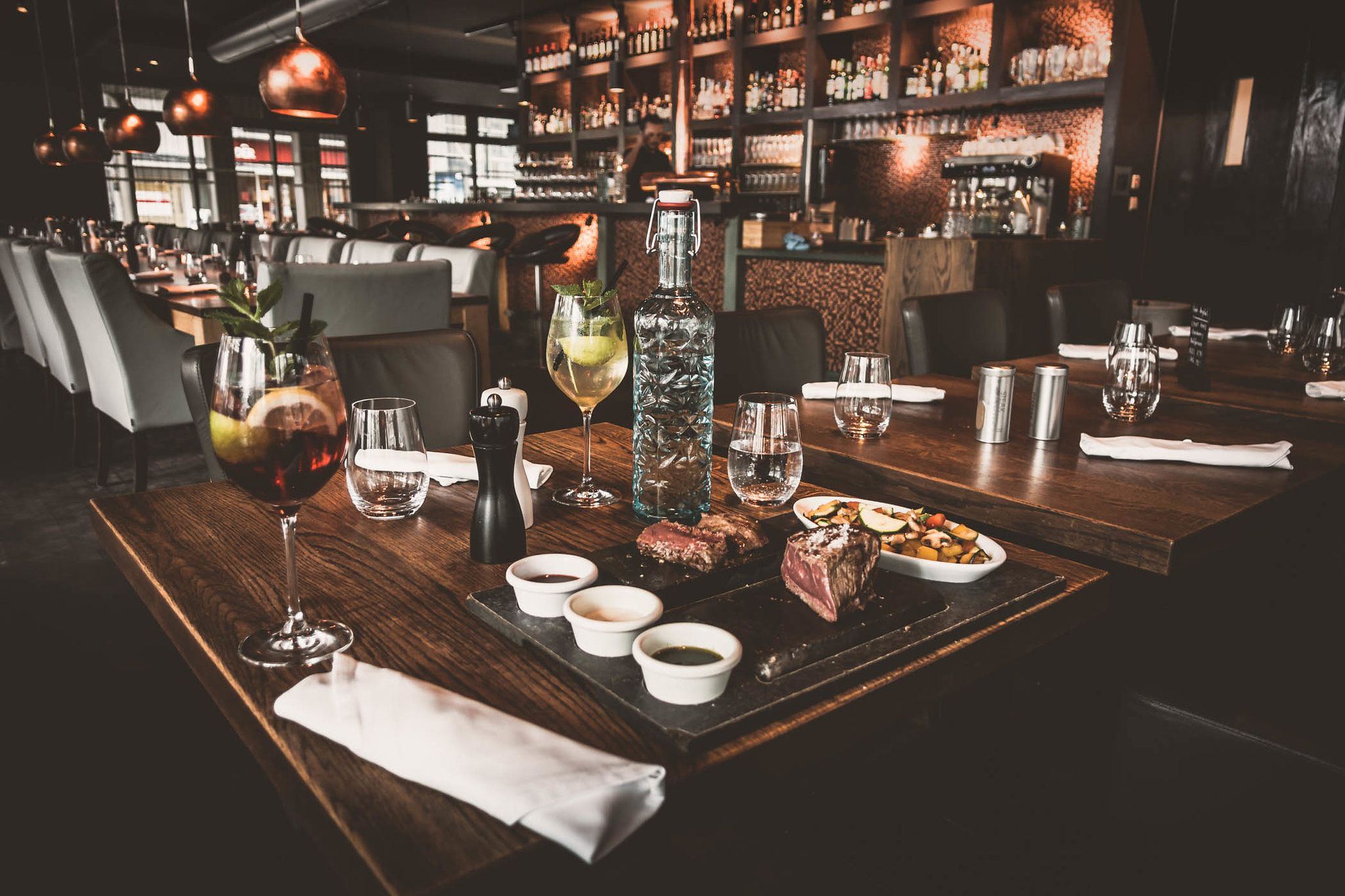 Elegantes Restaurant mit gedecktem Tisch, Getränken und Speisen.