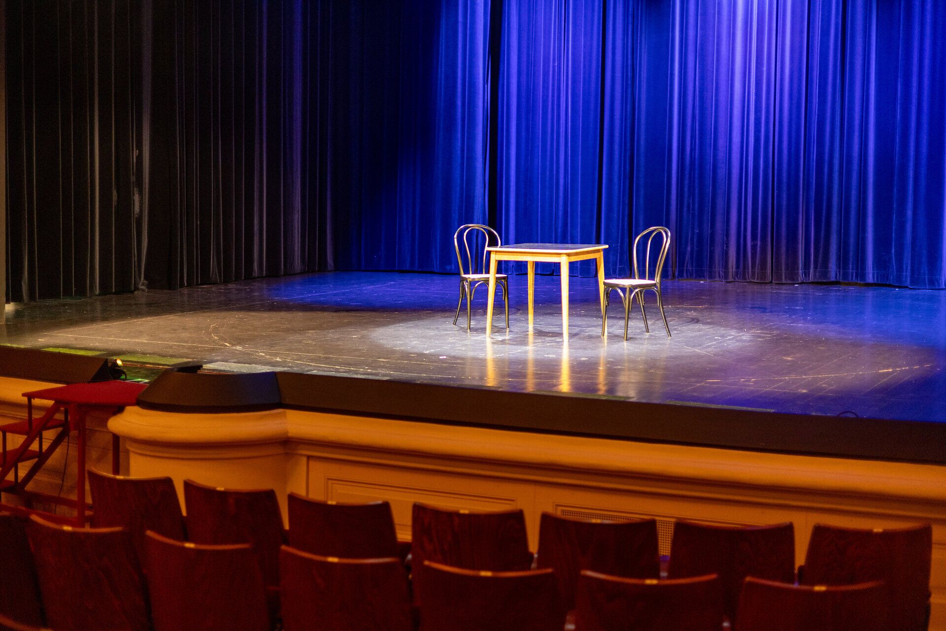 Die Bühne des Stadttheaters Berndorf strahlt eine einladende Atmosphäre aus, bereit für unvergessliche Aufführungen. Die sanften Lichter und der elegante Vorhang schaffen einen perfekten Rahmen für kulturelle Erlebnisse im Herzen des Wienerwaldes.