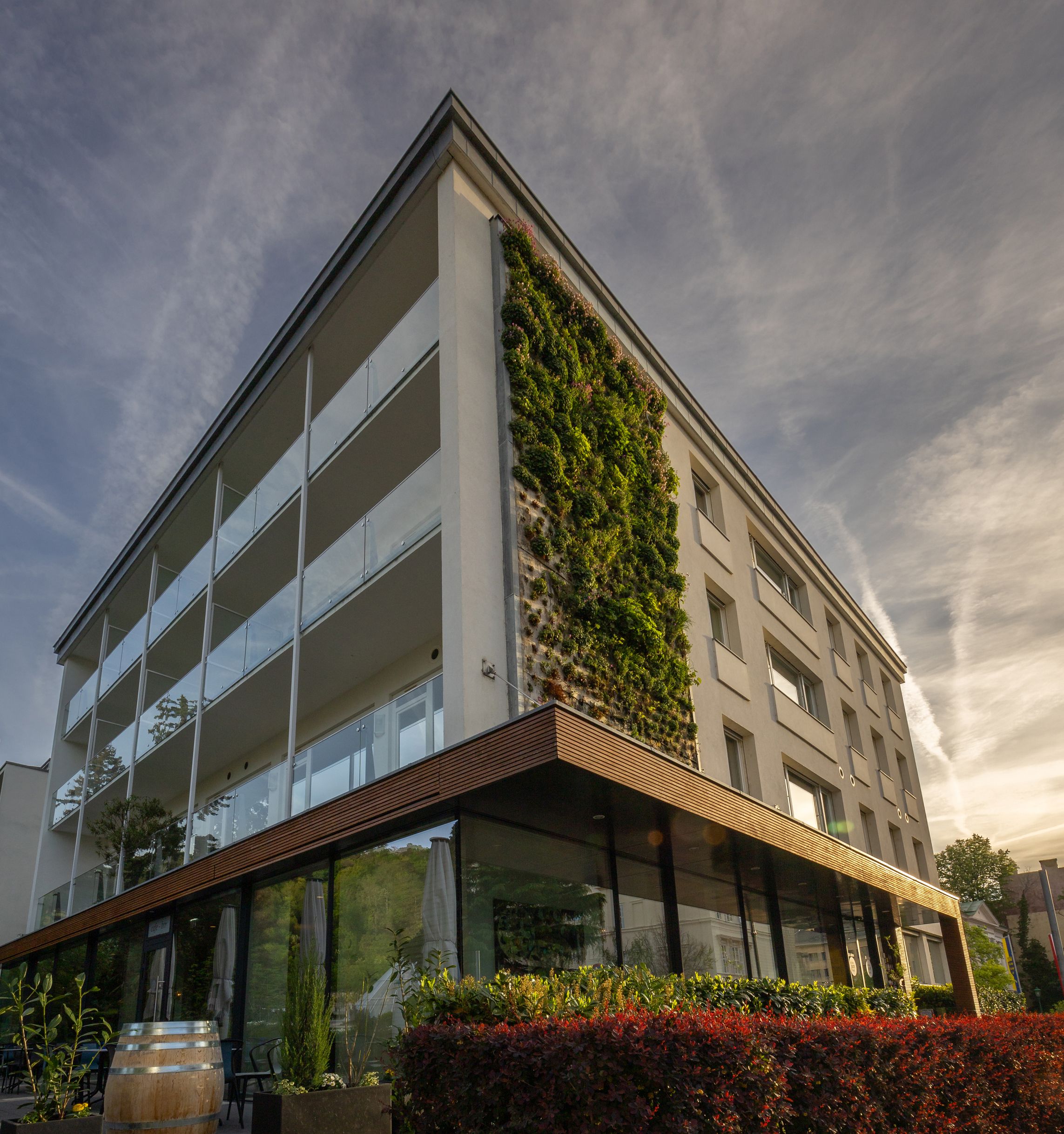 Modernes Hotelgebäude mit vertikaler Gartenwand und Glasfassade.